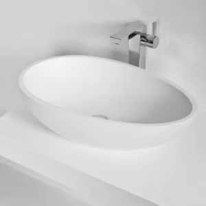 Vasque à poser en Solid Surface de dimensions 60 x 35 cm, fabriquée en matériau minéral massif, avec une finition mate, résistante aux tâches et à l'humidité, livrée avec une bonde pop-up en laiton chromé, facile d'entretien et offrant un raccordement aisé.